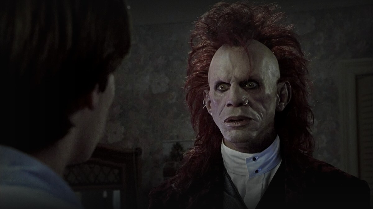Still from Brainscan (1994) — 16:9 still from letterboxd (the film's top-voted tmdb backdrop, served as a 1200x675 crop), baked in-process at brightness 0.80 with the standard desaturation and edge fades, output brightness 26.0